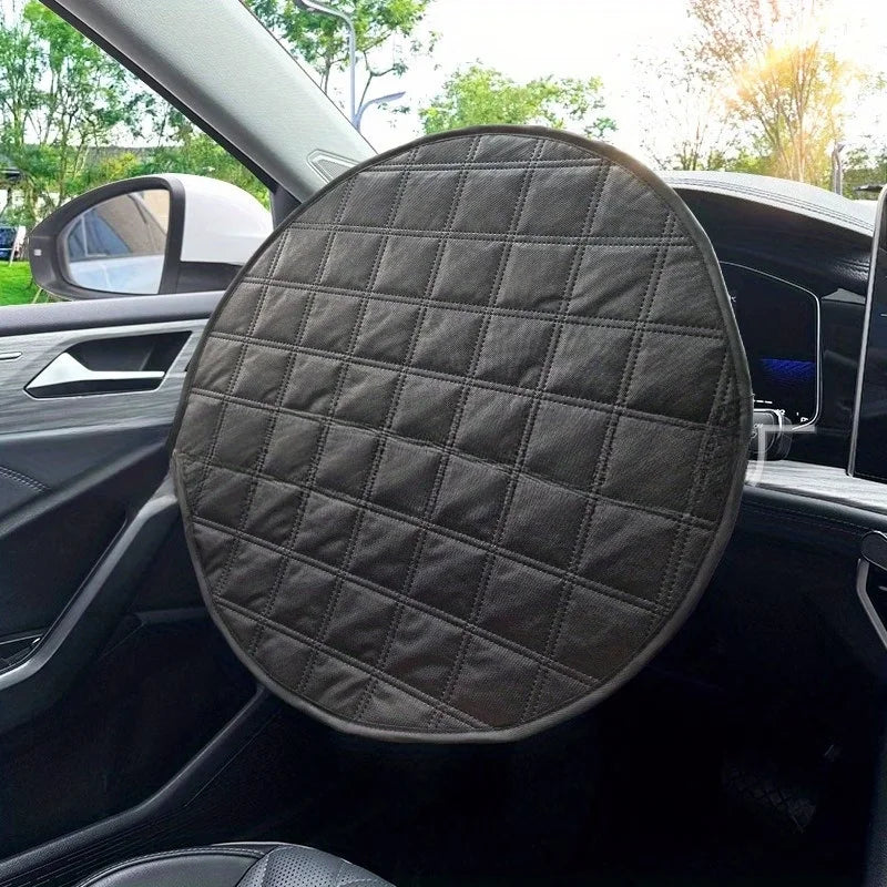A round black quilted car seat cover with a diamond-stitched pattern, shown installed on a car's front passenger seat.