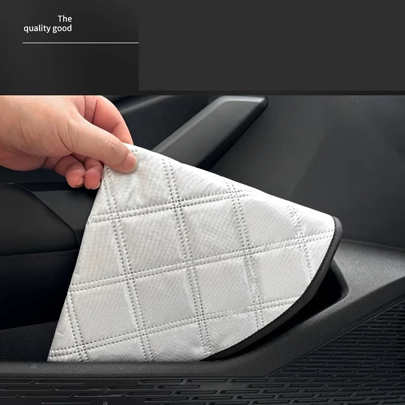 White triangular car air filter being held by a hand on a car dashboard.