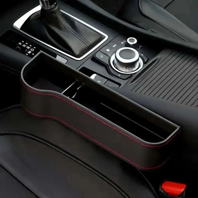 Car armrest organizer with red stitching on a car dashboard