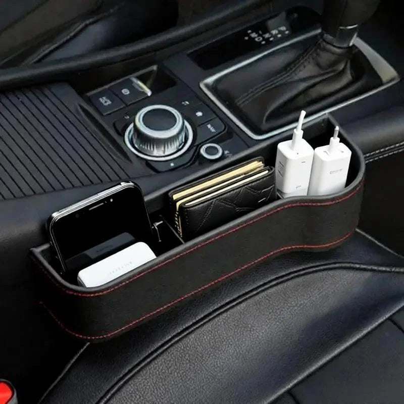 Car console organizer with phone, wallet, and charging cables in a vehicle.